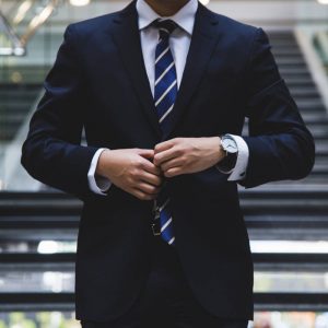Photo of a man doing up a suit jacket
