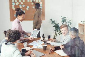 Photo of a group of people talking at a desk